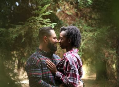 A couple embraces in the woods during their engagement session.