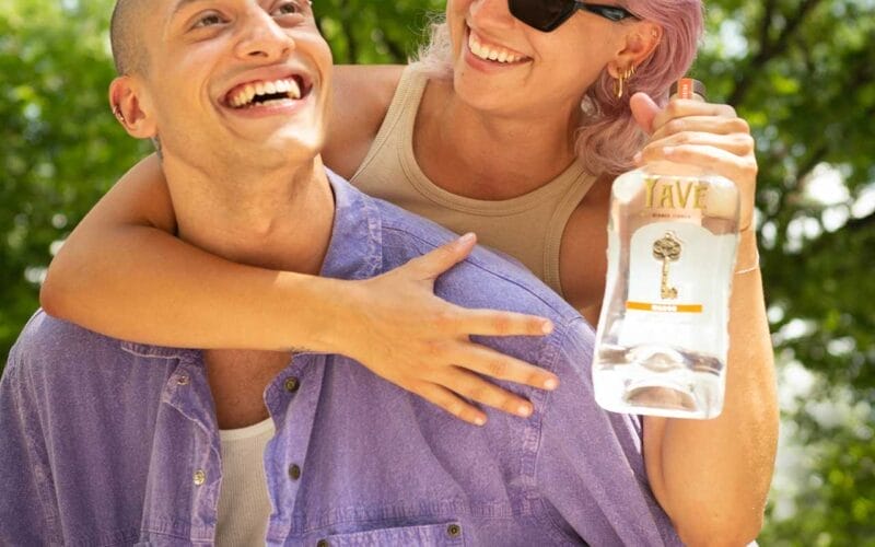 A man and woman holding a bottle of gin.